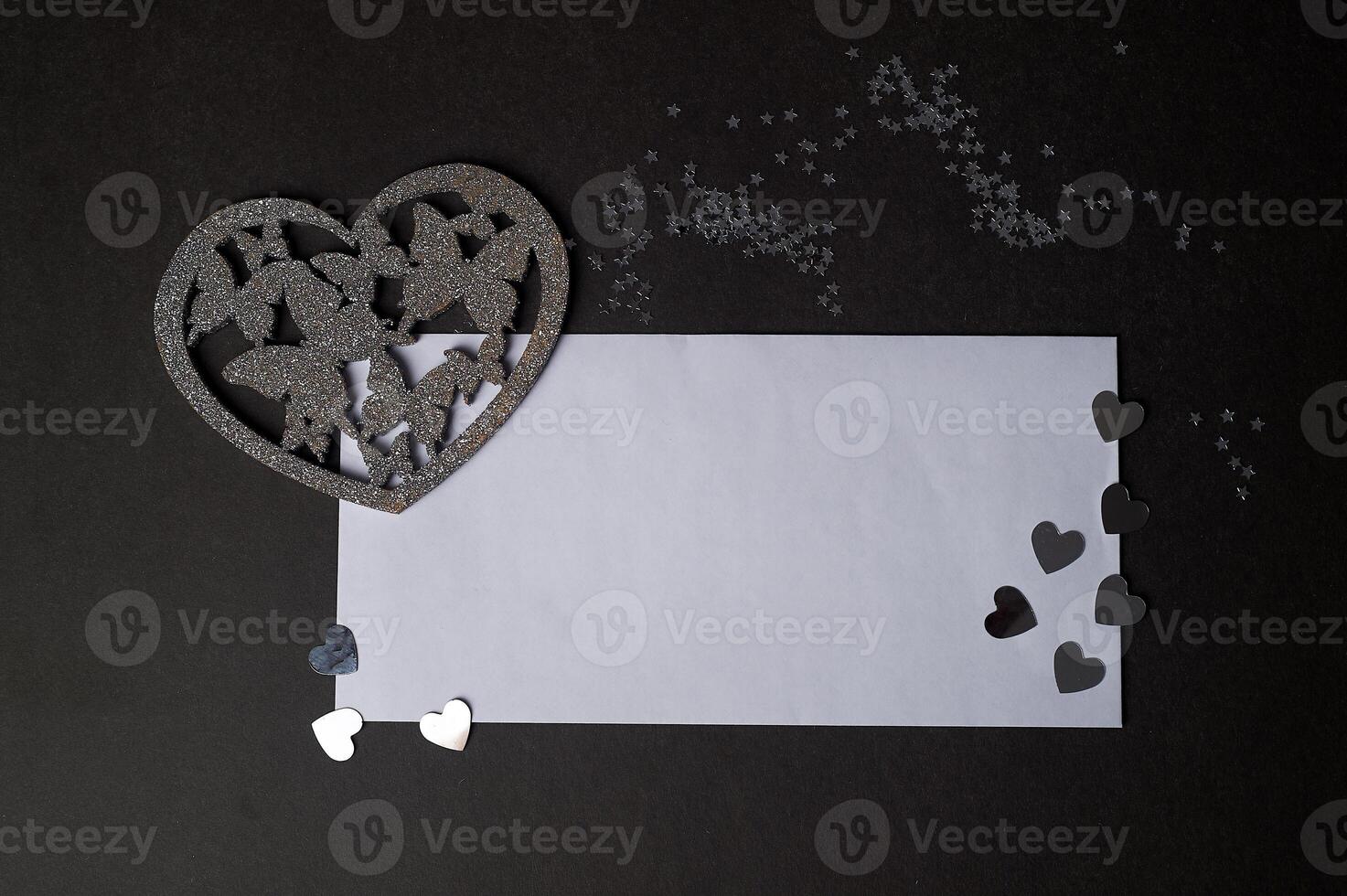 Valentine's day,a Declaration of love. Silver heart with butterflies. Butterflies in the stomach. Silver heart with butterflies on a dark graphite background.And a white envelope for the inscription photo