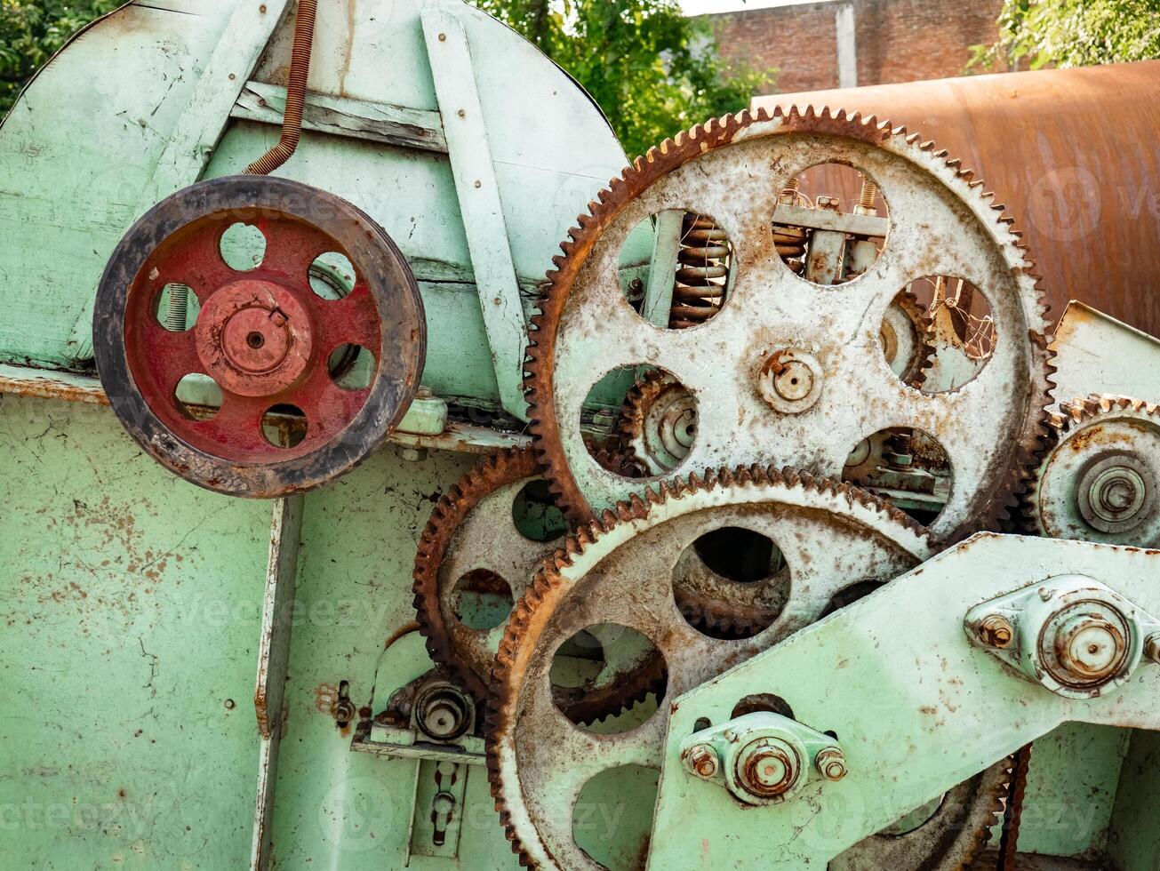 the gears on the machine are rusting and the green color of the paint is fading photo