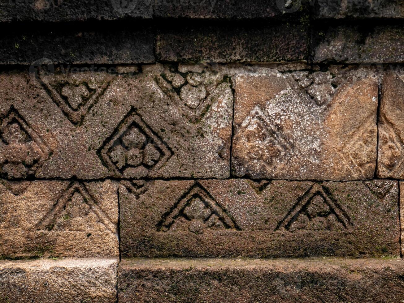 patterns carved into the walls of restored old temples in Indonesia photo