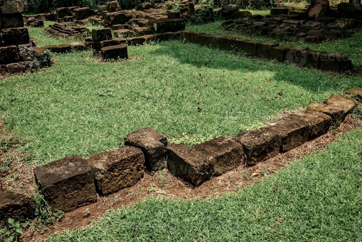 the arrangement of ancient temple stones in a park that has not yet been completely restored photo