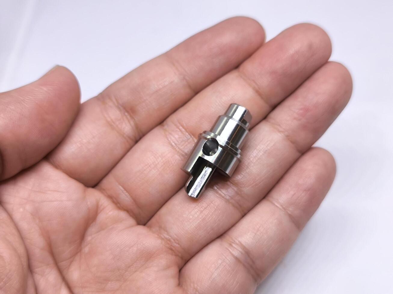 Close up of hand holding metal cnc part. cnc turning parts. photo