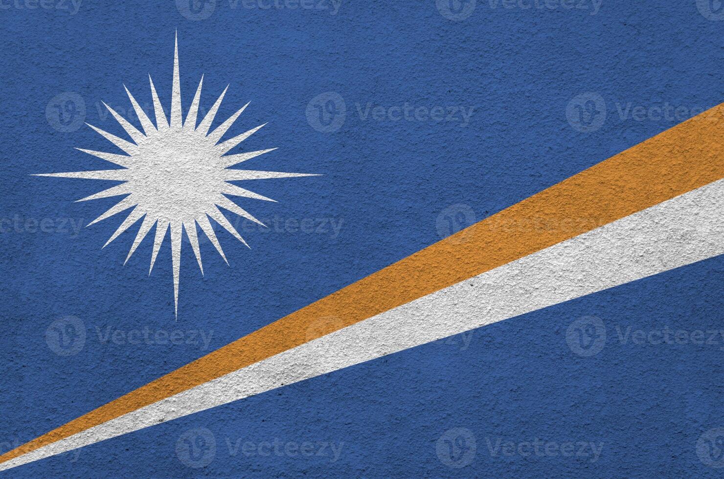 Marshall Islands flag depicted in bright paint colors on old relief plastering wall. Textured banner on rough background photo