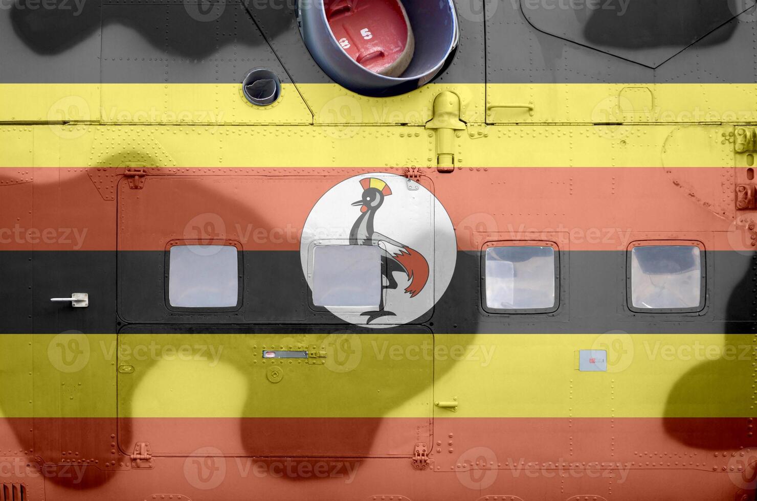 Uganda flag depicted on side part of military armored helicopter closeup. Army forces aircraft conceptual background photo