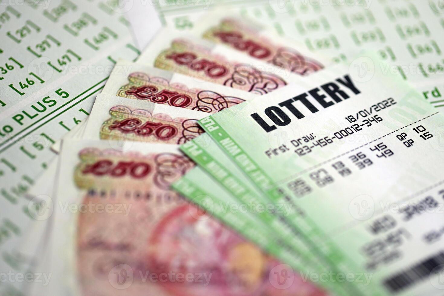 Green lottery tickets and Great Britain pounds money bills on blank with numbers for playing lottery photo