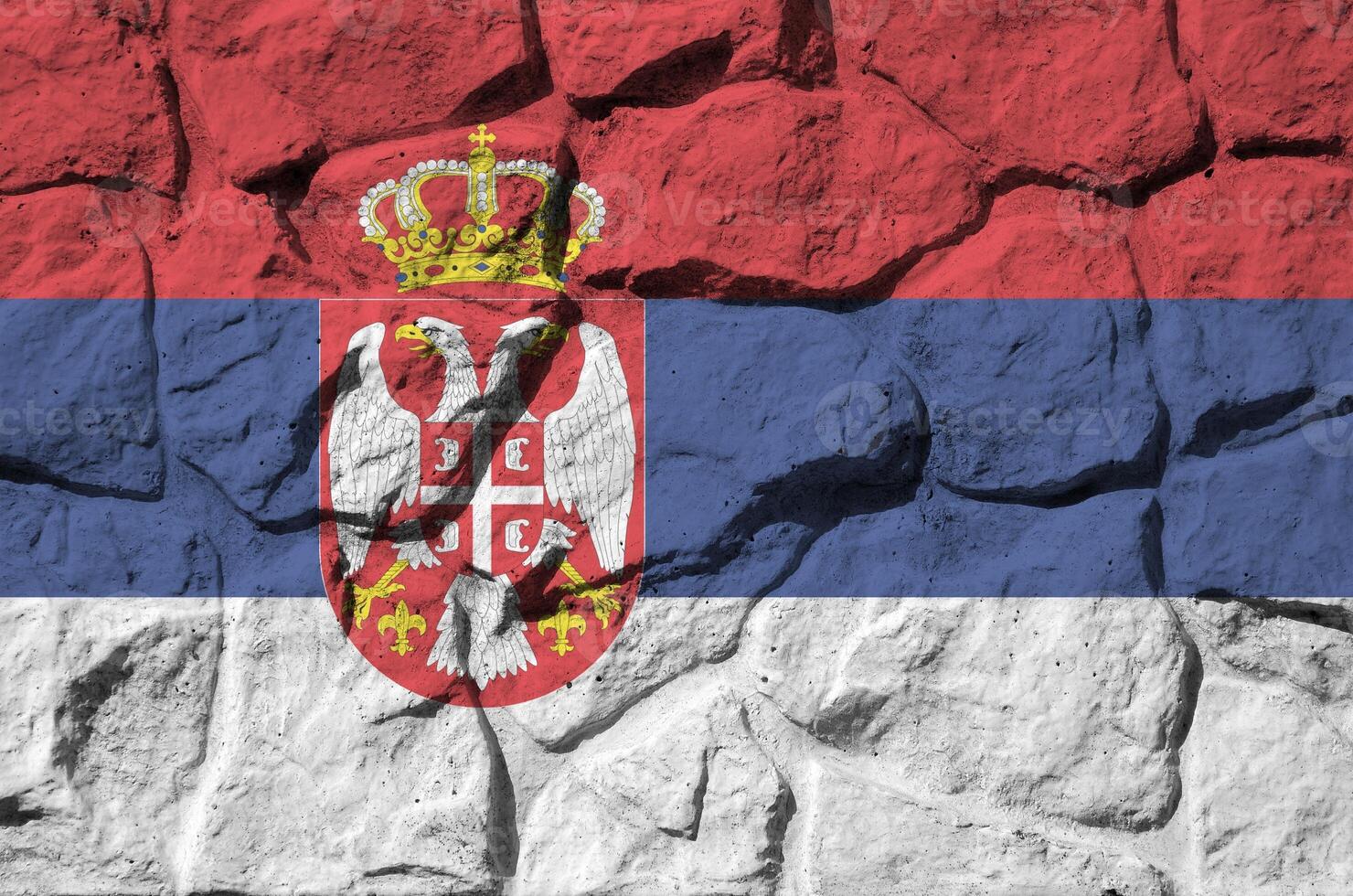 Serbia flag depicted in paint colors on old stone wall closeup. Textured banner on rock wall background photo