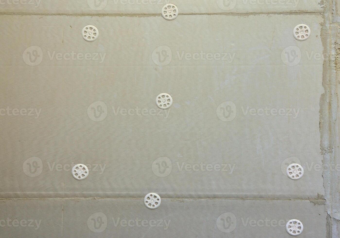 The texture of the wall, covered with gray foam polystyrene plates, which are reinforced with plastic umbrella dowels. Stage of wall insulation photo