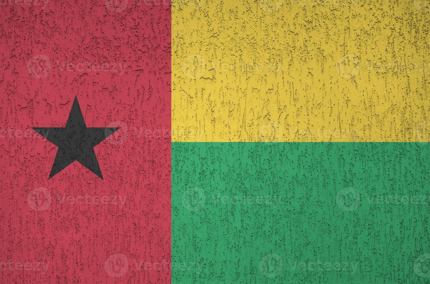 Guinea Bissau flag depicted in bright paint colors on old relief plastering wall. Textured banner on rough background photo