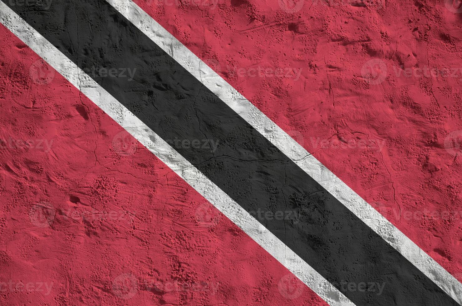 Trinidad and Tobago flag depicted in bright paint colors on old relief plastering wall. Textured banner on rough background photo
