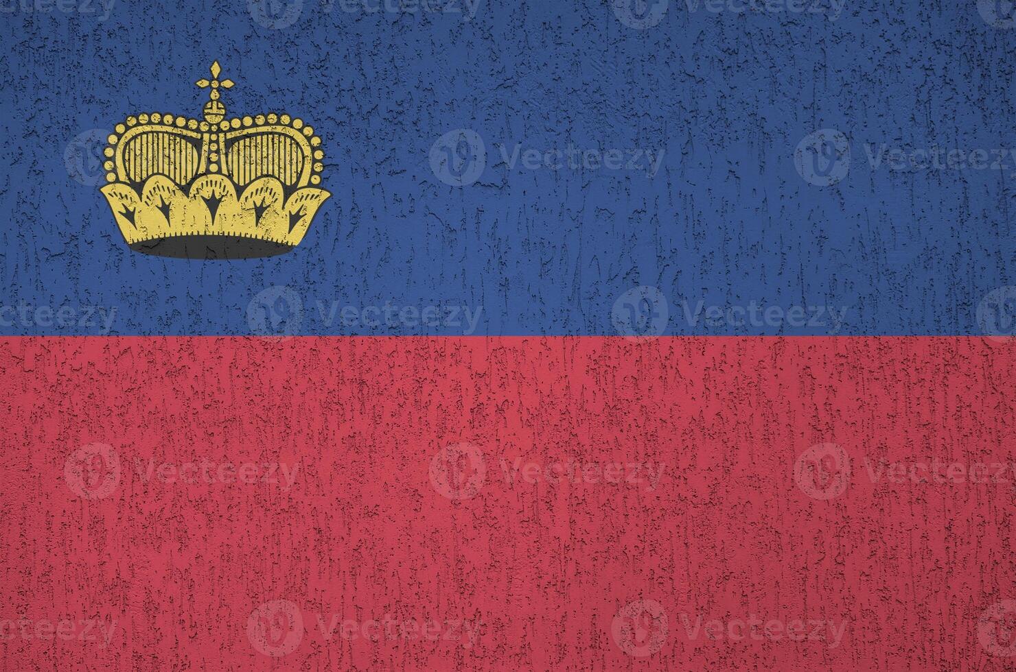 Liechtenstein flag depicted in bright paint colors on old relief plastering wall. Textured banner on rough background photo