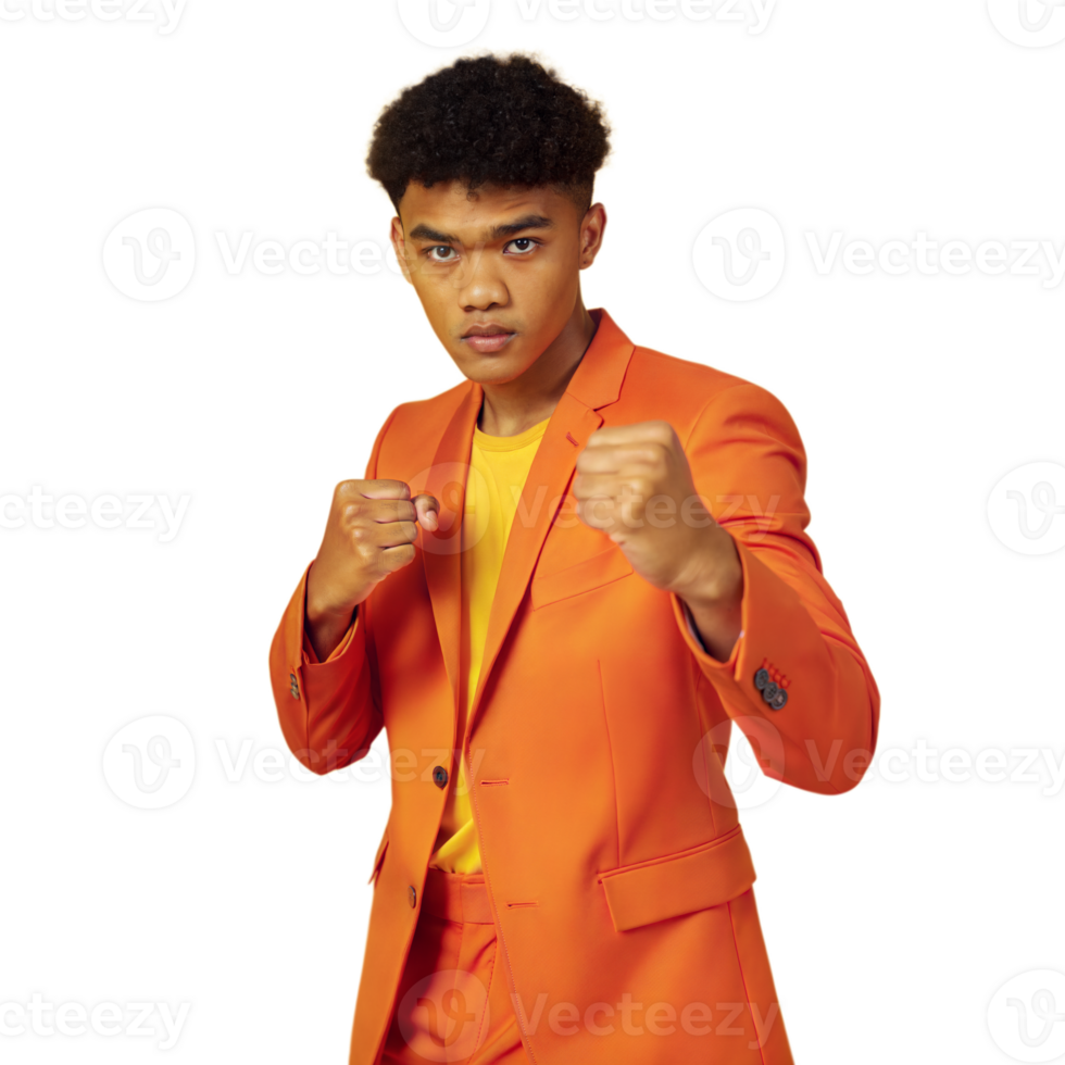 Confident young man in orange suit with fists raised on transparent background png