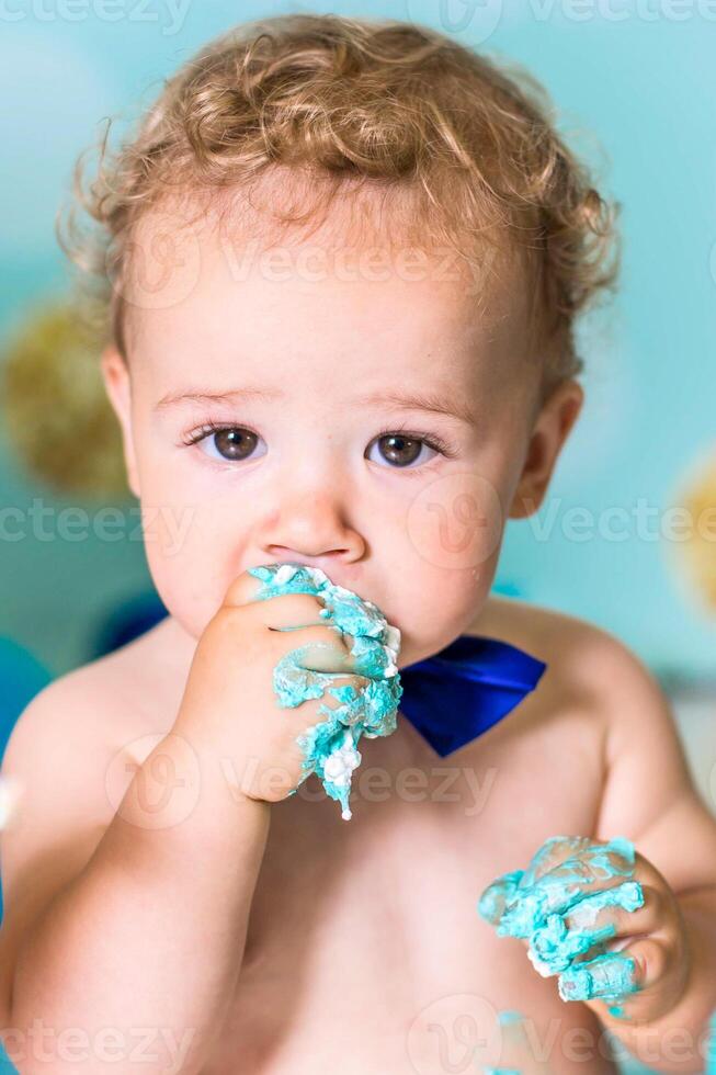 Baby boy playing with a cake during cake smash birthday party photo