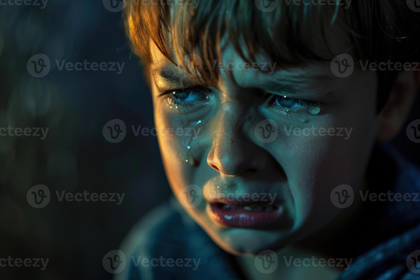 Sad little boy in tears, his face lit by a dim, atmospheric light that highlights the profound sadness in his eyes. Emotional depth and vulnerability of childhood. Mental health. photo