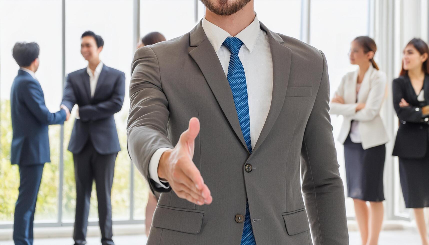 Close up businessman hand shaking with his team in the background photo