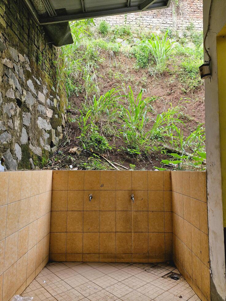 A corner of a simple shower area that is not well-maintained or may not have been completed photo