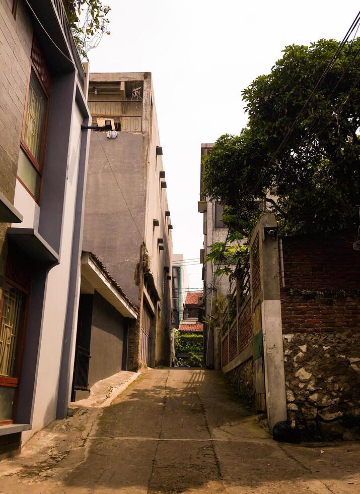 Roads in dense settlements leading to main roads are less than 2 meters wide surrounded by residential walls photo