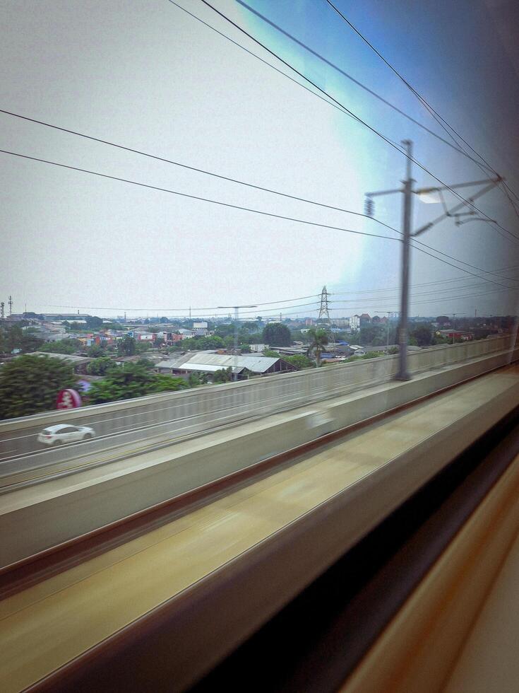 From inside the KCIC Jakarta - Bandung express train, Indonesia as it passes through the elevated highway and through the city. photo