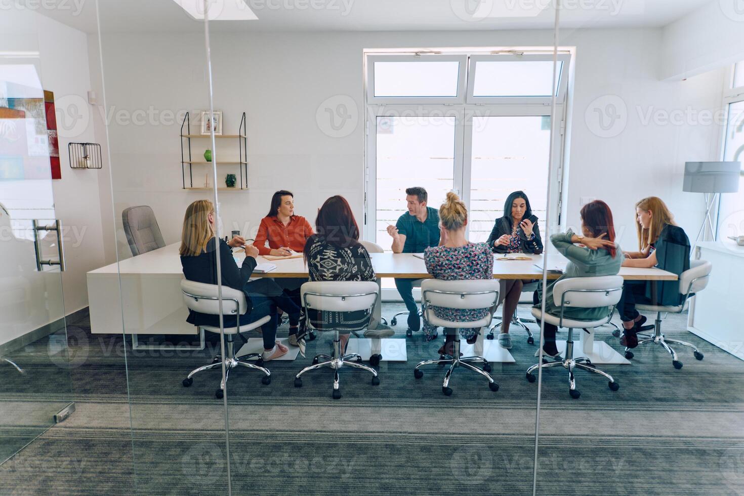 Diverse Business Team Discussing Projects in a Modern Glass Office. photo