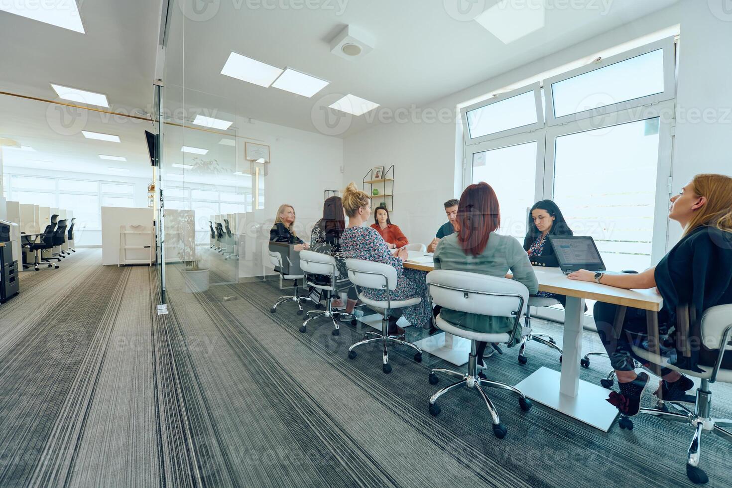 Diverse Business Team Discussing Projects in a Modern Glass Office. photo