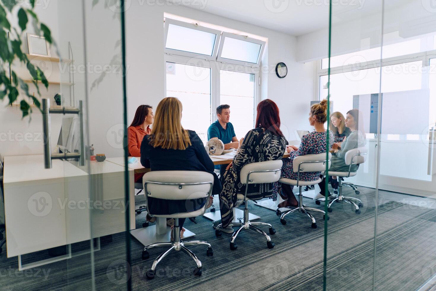 Diverse Business Team Discussing Projects in a Modern Glass Office. photo