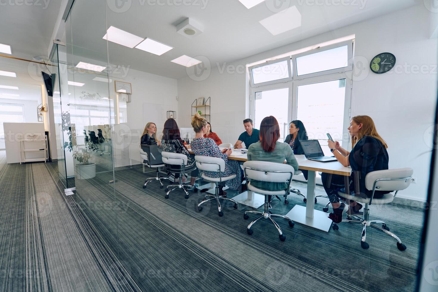 Diverse Business Team Discussing Projects in a Modern Glass Office. photo