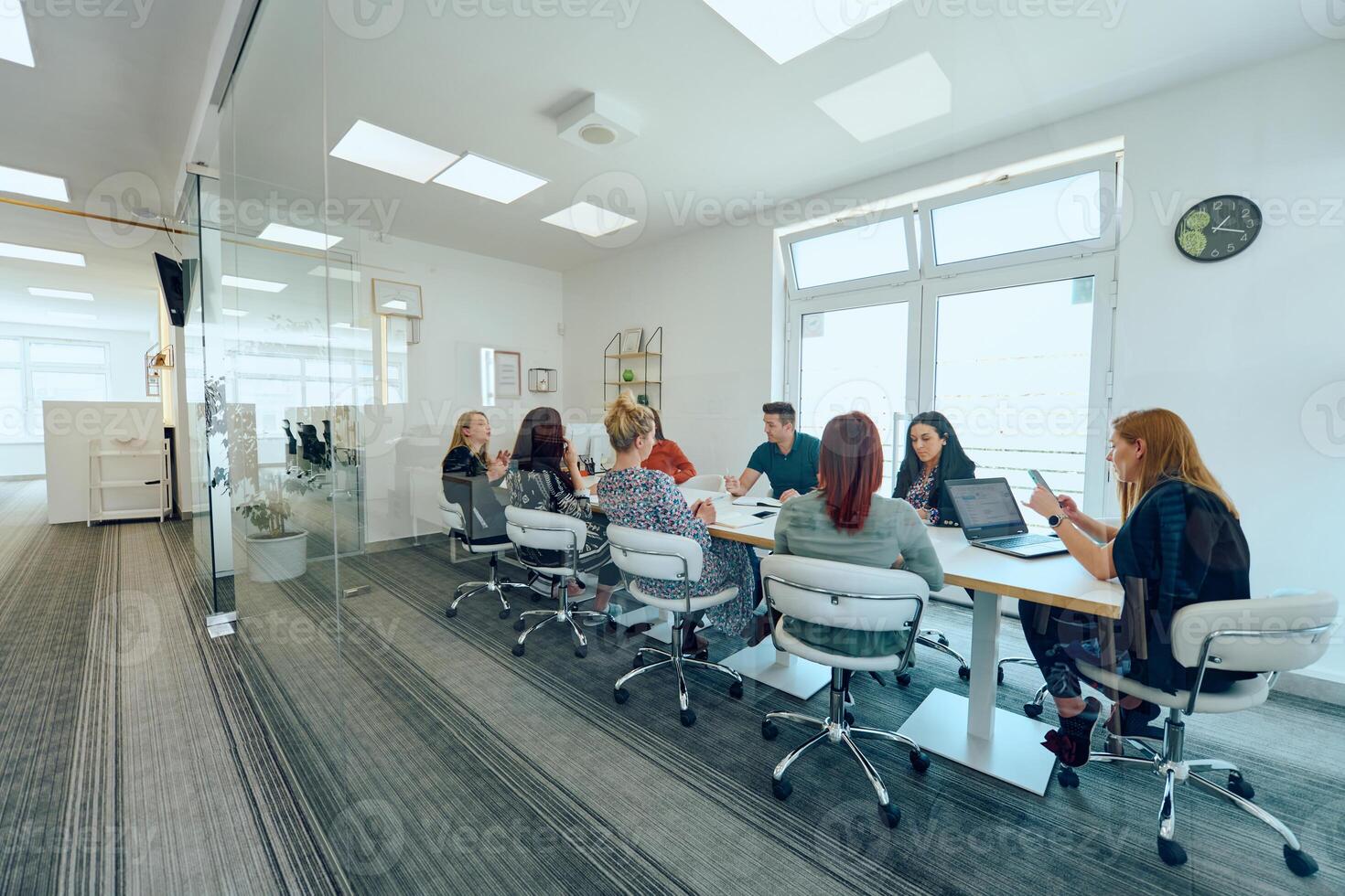 Diverse Business Team Discussing Projects in a Modern Glass Office. photo