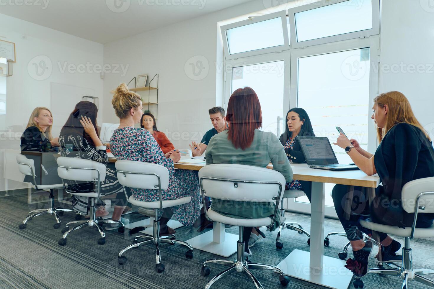Diverse Business Team Discussing Projects in a Modern Glass Office. photo