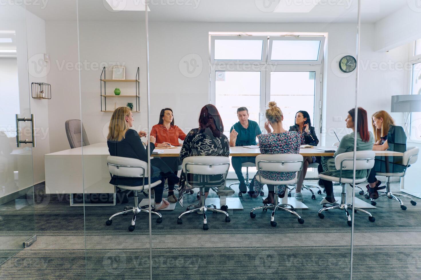 Diverse Business Team Discussing Projects in a Modern Glass Office. photo