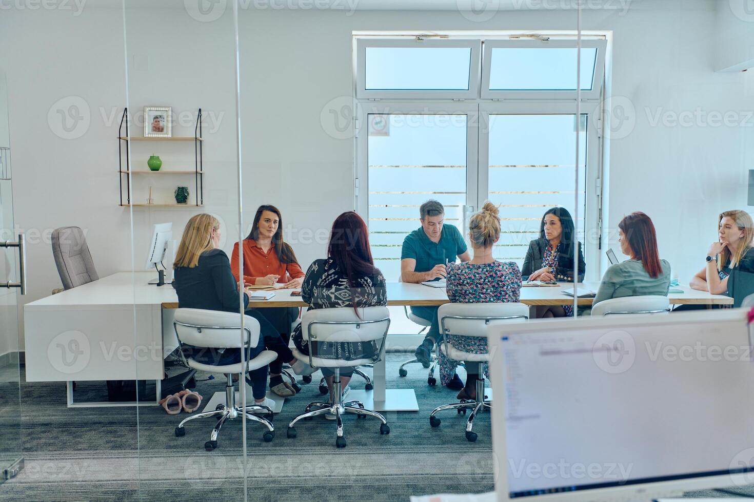 Diverse Business Team Discussing Projects in a Modern Glass Office. photo