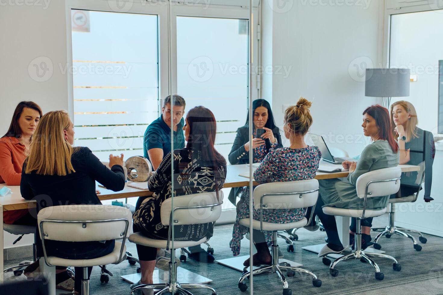 Diverse Business Team Discussing Projects in a Modern Glass Office. photo