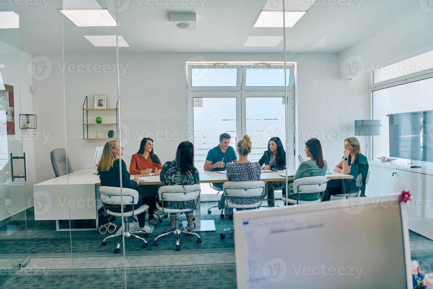 Diverse Business Team Discussing Projects in a Modern Glass Office. photo