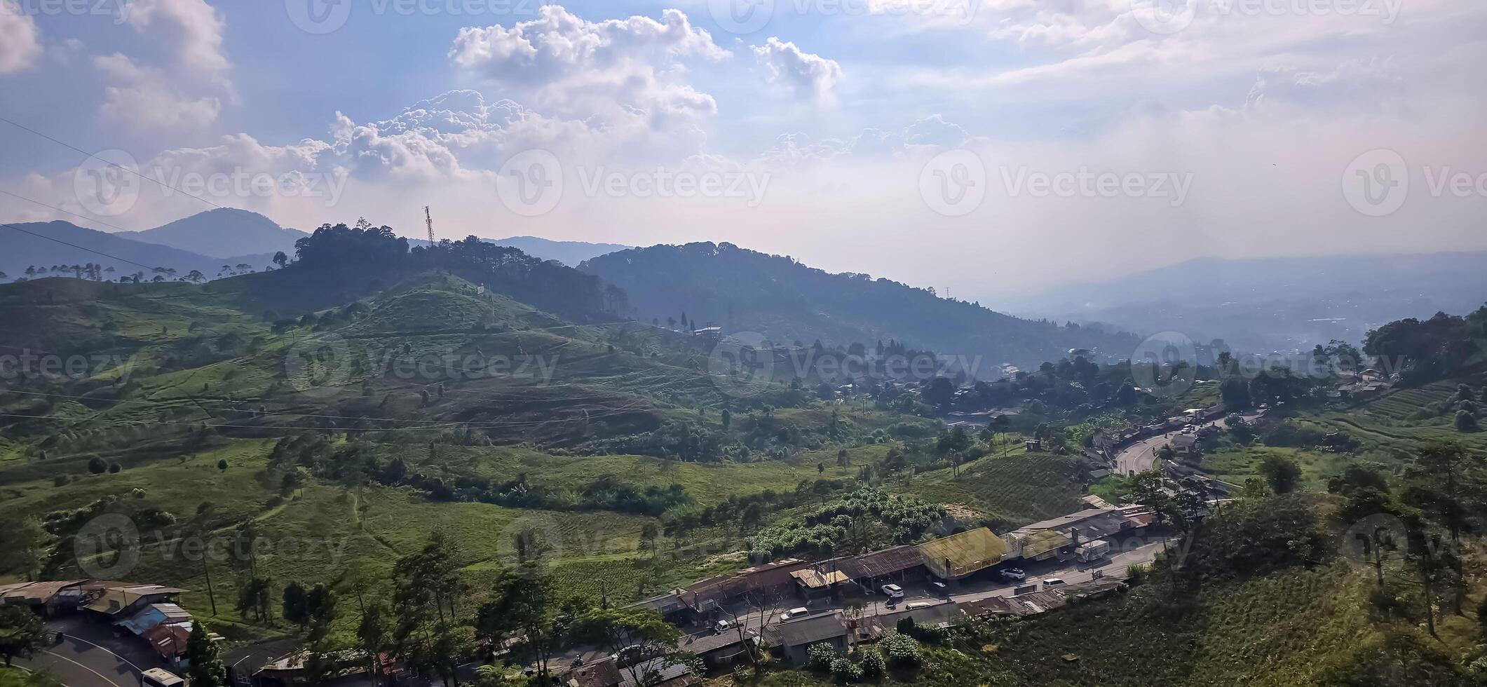 Beautiful scenery on top of hill, green view and blue sky with clouds, location at puncak pass, bogor, indonesia photo