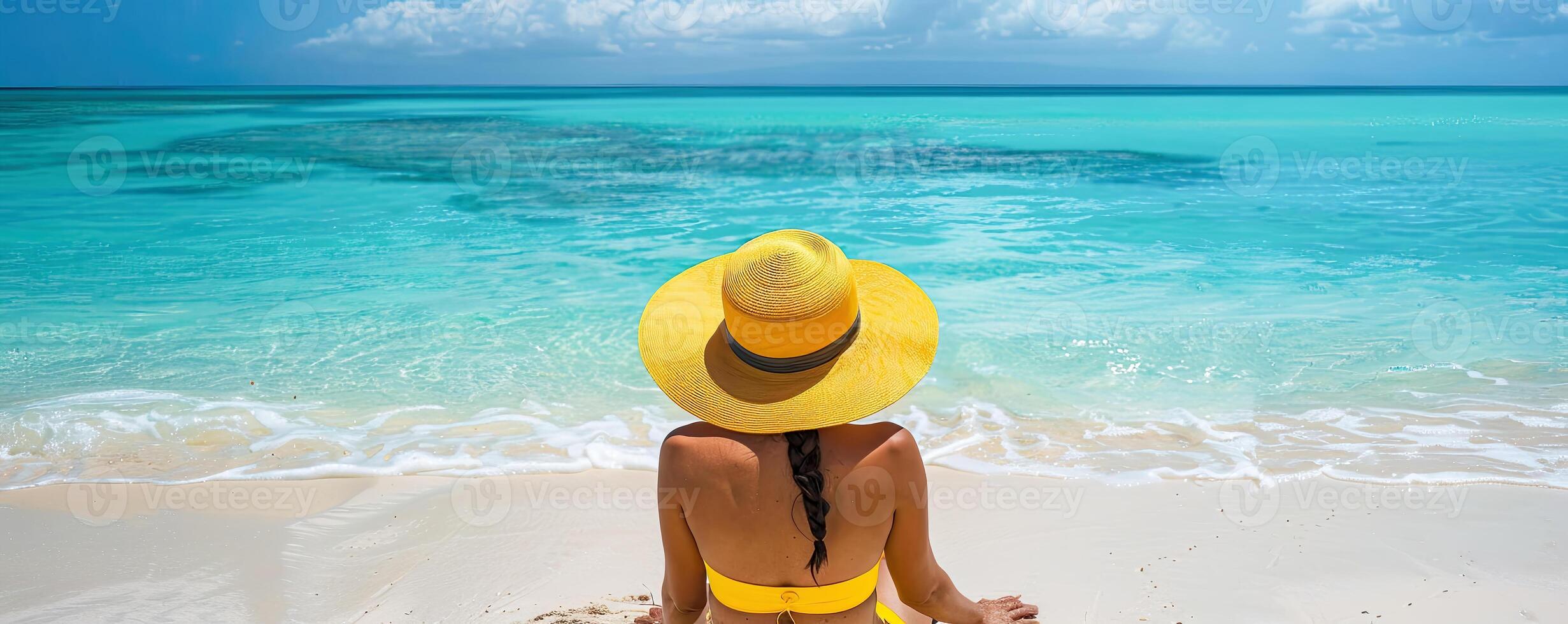 Summer Vacation. A woman sitting on a beach in a yellow bikini and yellow straw hat. Travel and lifestyle Concept photo