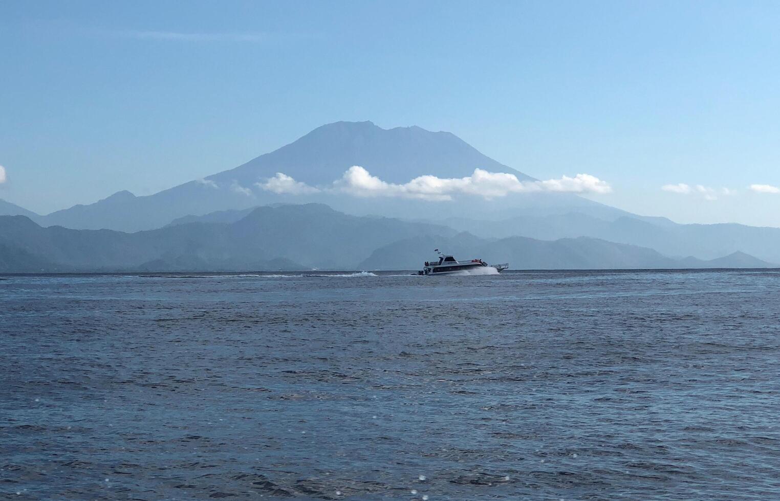 Speed boat running on the sea with mountain background. photo