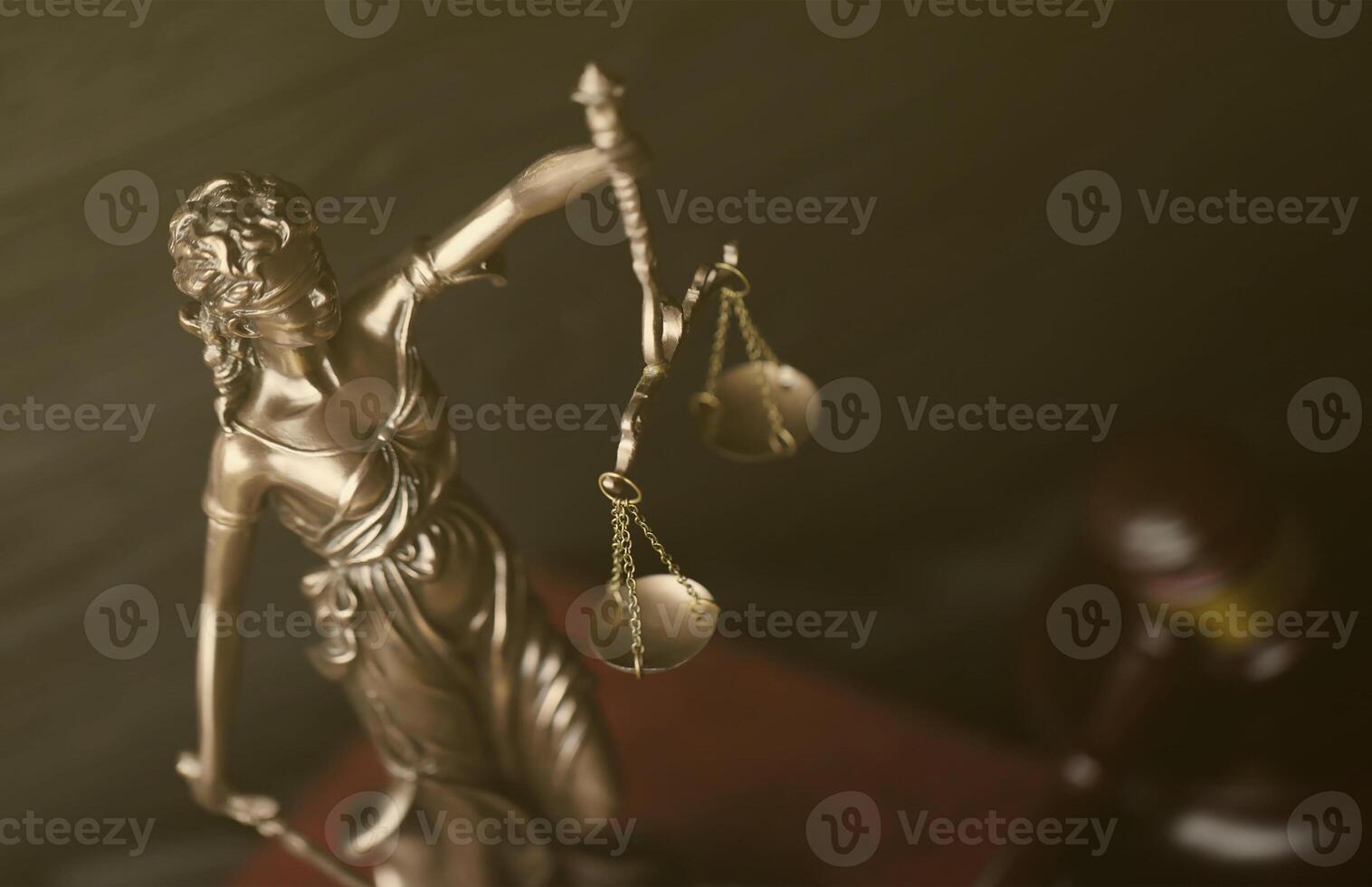 The Statue of Justice - lady justice or justitia the Roman goddess of Justice. Statue on brown book with judge gavel. Concept of judicial trial, courtroom process and lawyers work photo