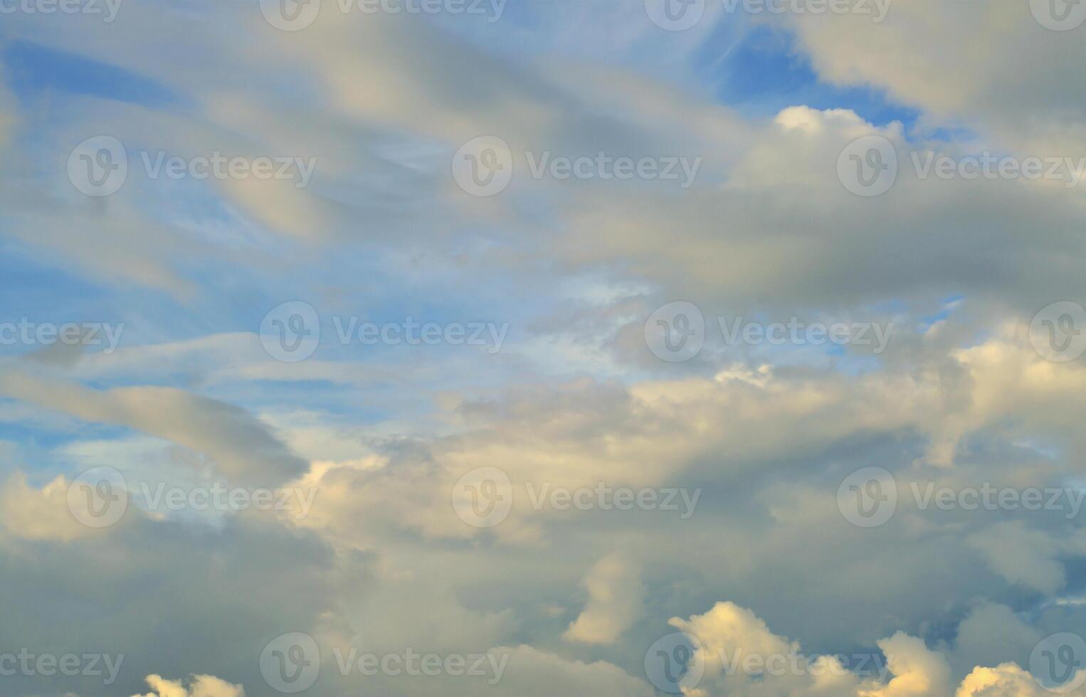 A blue cloudy sky with many small clouds blocking the sun photo