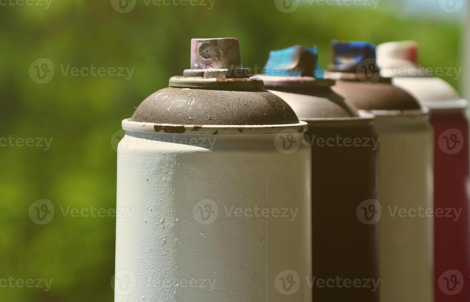 A few used aerosol paint sprayers lie on the windowsill in the workshop of a graffiti artist. The concept of street art and illegal drawing on the walls. Youth hobby photo