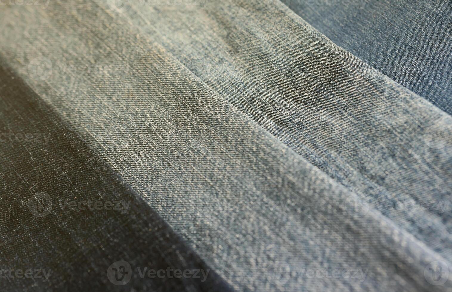 Detailed abstract texture of dark blue denim cloth. Background image of old used denim trousers fabric photo