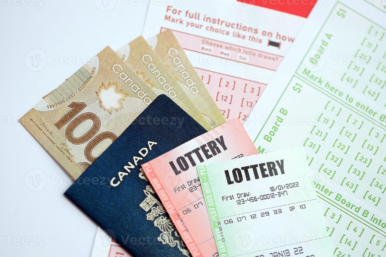 Lottery tickets lies with canadian dollars on gambling sheets with numbers for marking to play lottery photo
