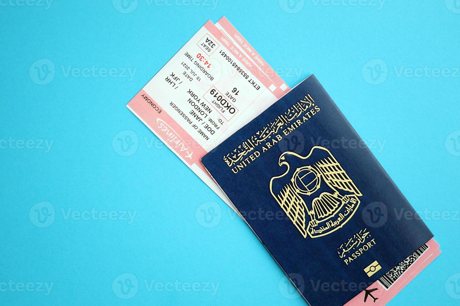 Blue United Arab Emirates passport with airline tickets on blue background close up photo