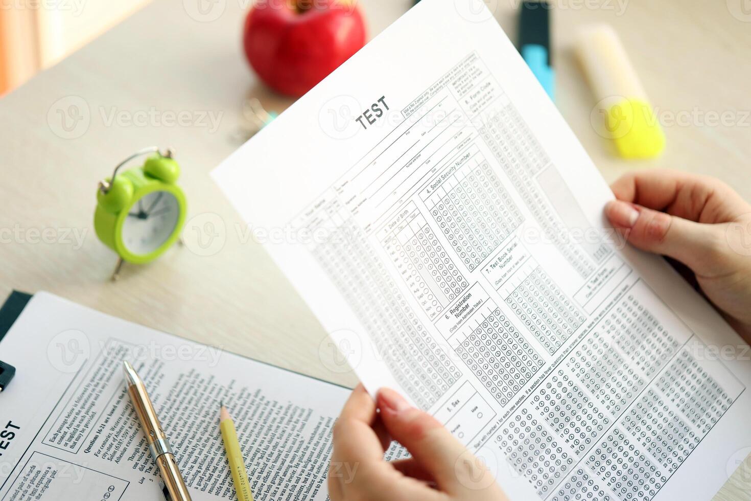 Female student hands testing in exercise and hold exam paper sheet with pencil at school test room photo