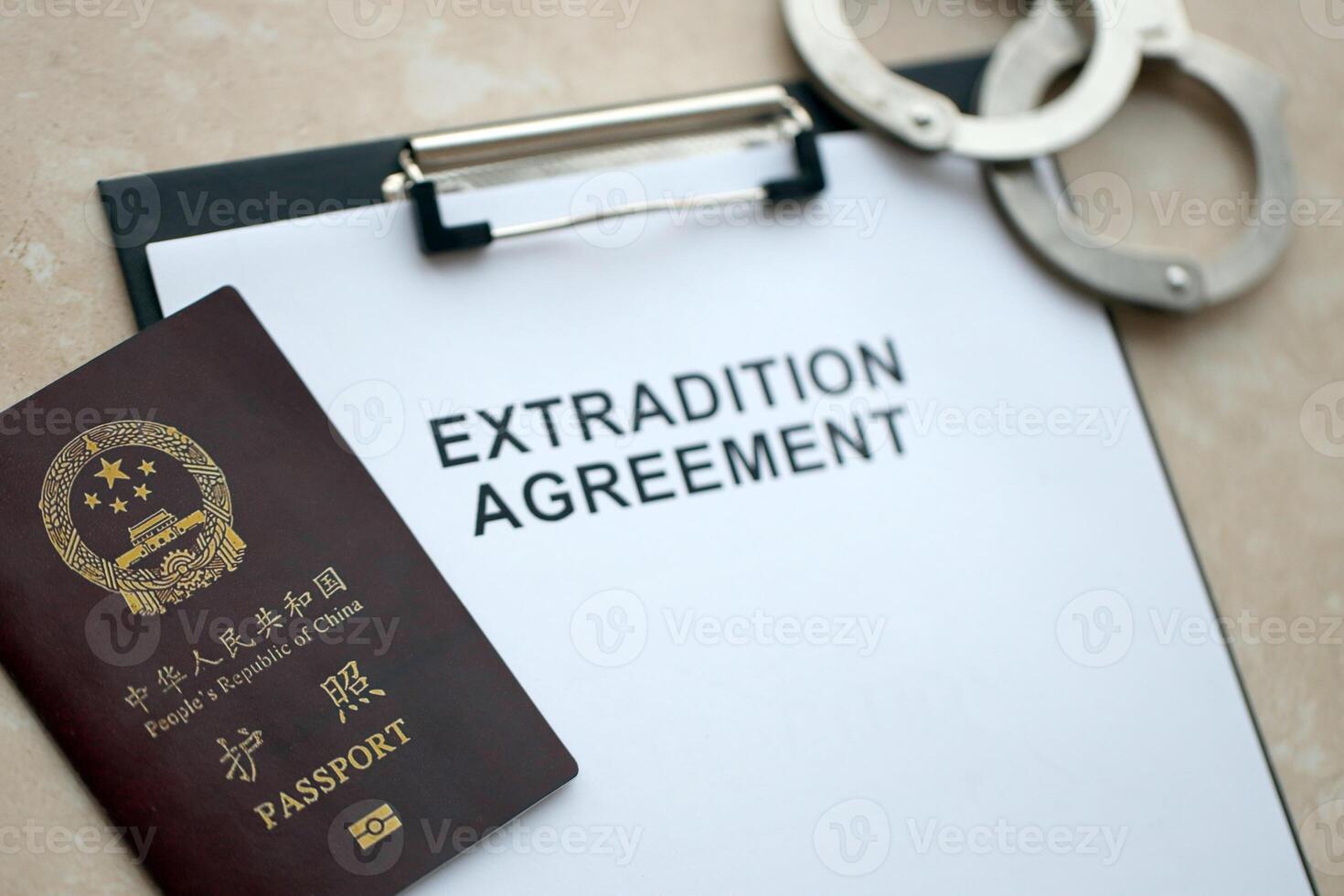Passport of China Republic and Extradition Agreement with handcuffs on table photo