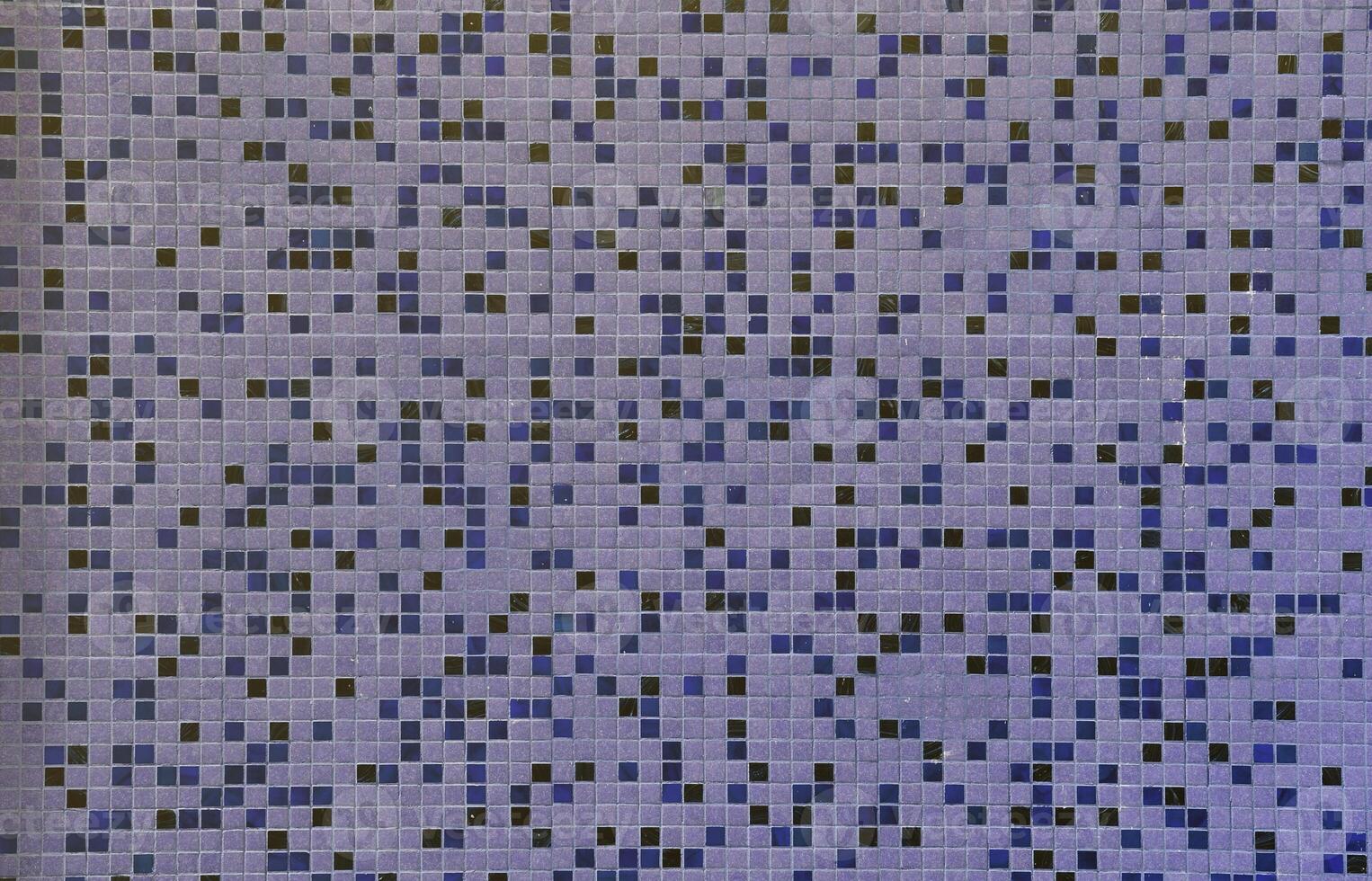 The texture of the wall, decorated with a mosaic of various small square tiles. Abstract pattern of ceramic tiles on the wall photo