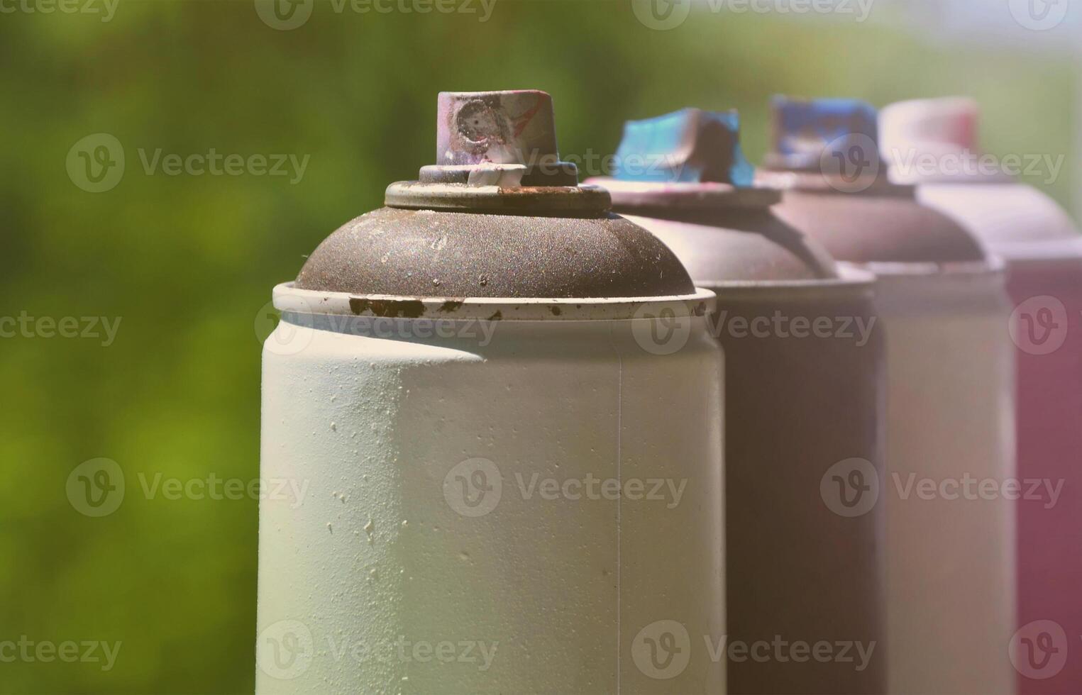 A few used aerosol paint sprayers lie on the windowsill in the workshop of a graffiti artist. The concept of street art and illegal drawing on the walls. Youth hobby photo