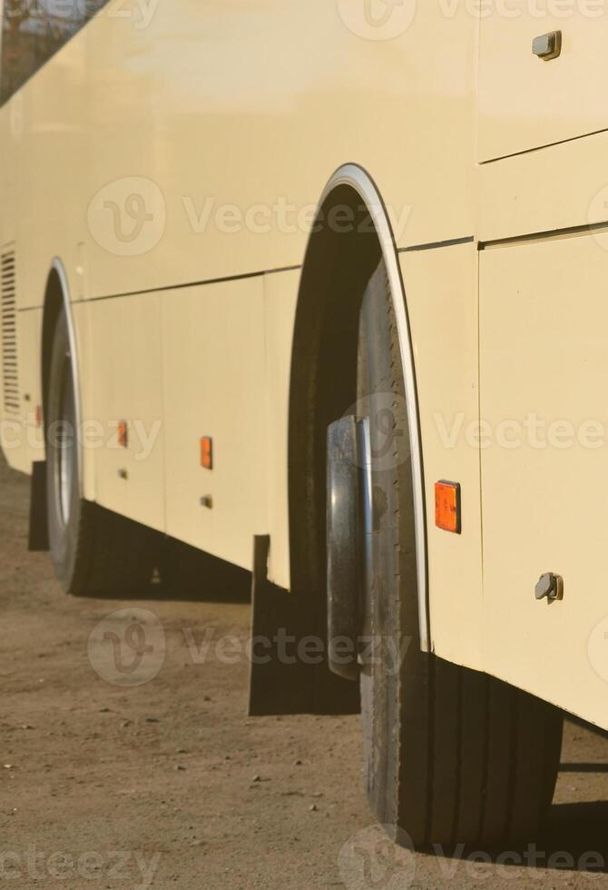 Photo of the hull of a large and long yellow bus. Close-up front view of a passenger vehicle for transportation and tourism
