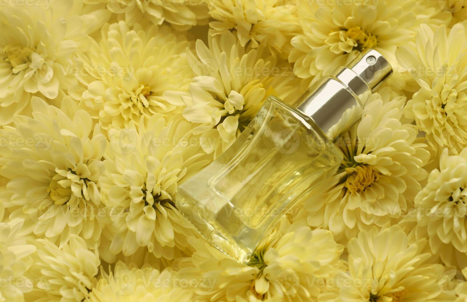 Women fragrance perfume bottle with flowers background close up. Unnamed blank sprayer bottle of perfume photo