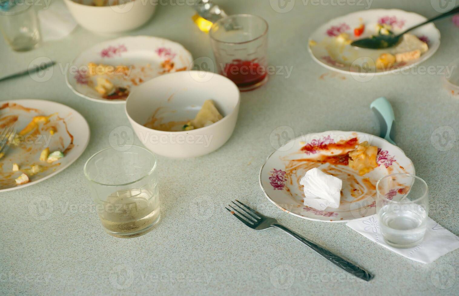 Empty dirty plates with spoons and forks on the table after meal. Banquet ending concept. Unwashed dishes photo
