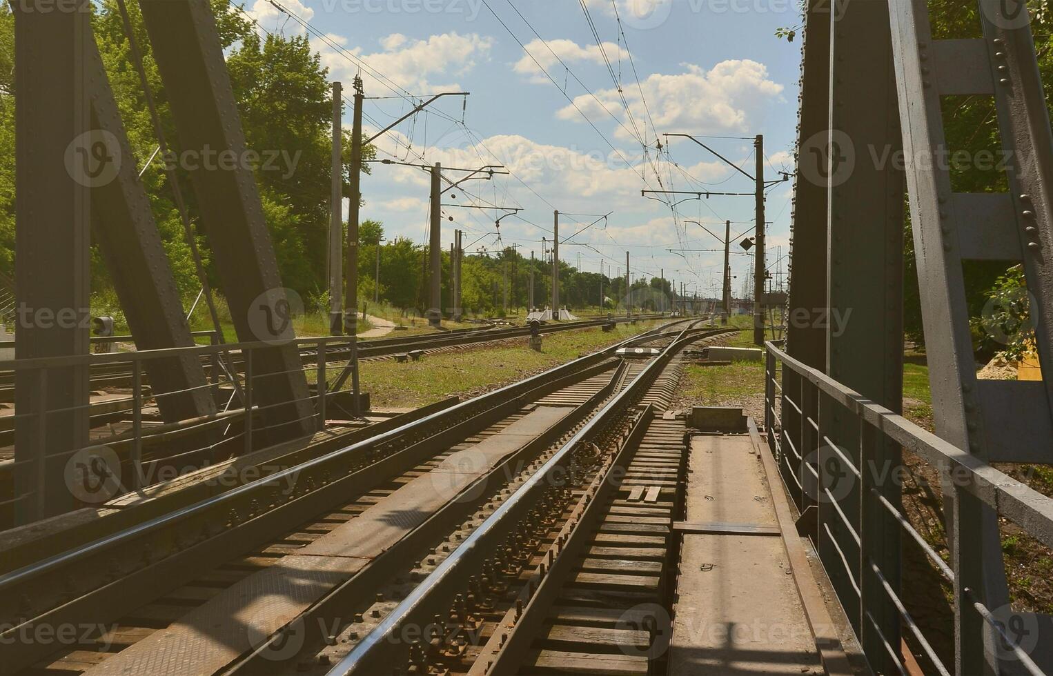 Summer day railway landscape with a view from the railway bridge to the suburban passenger station photo