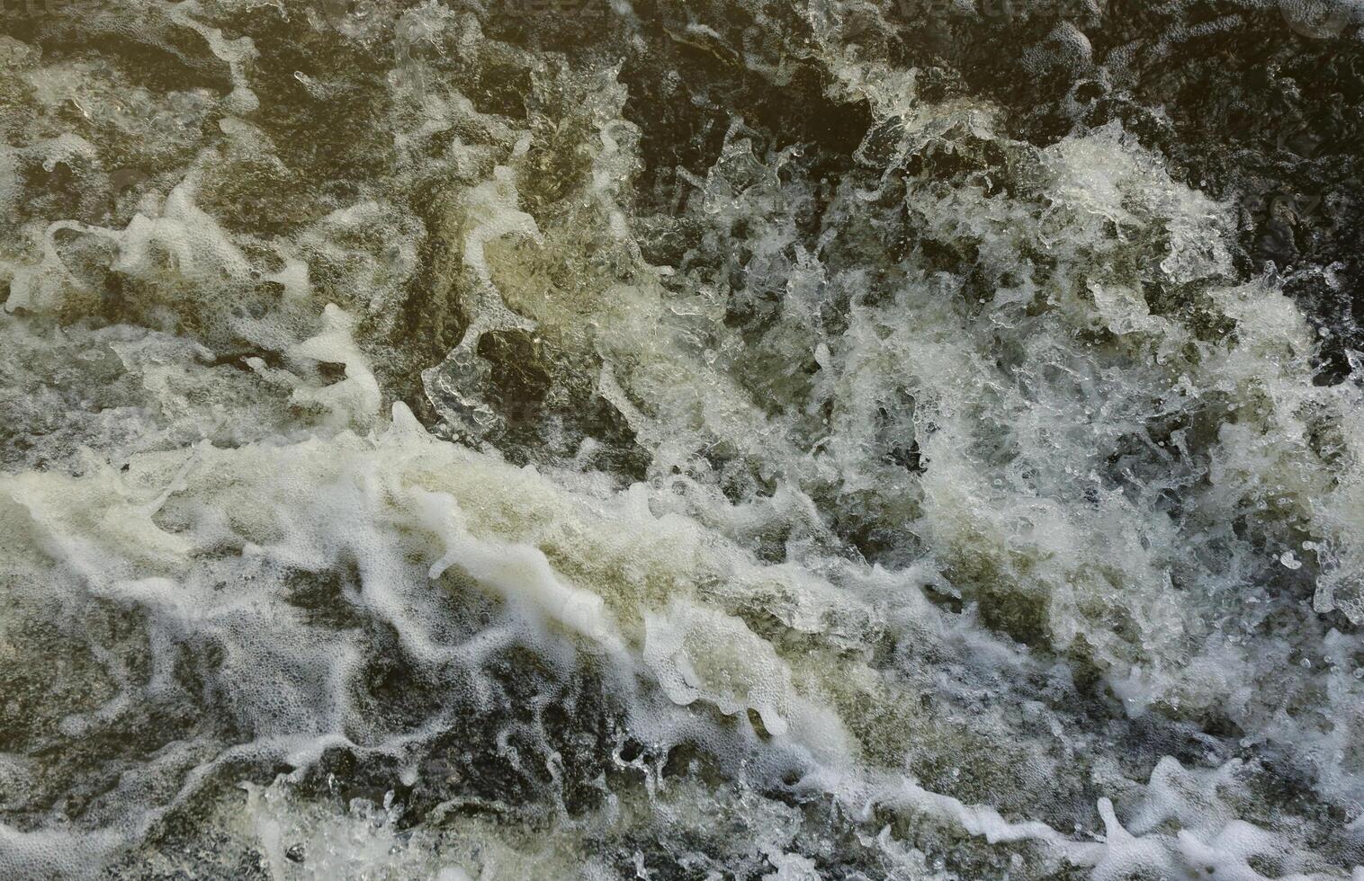 Waves of water of the river and the sea meet each other during high tide and low tide. Deep blue stormy sea water surface with white foam and waves pattern, background photo