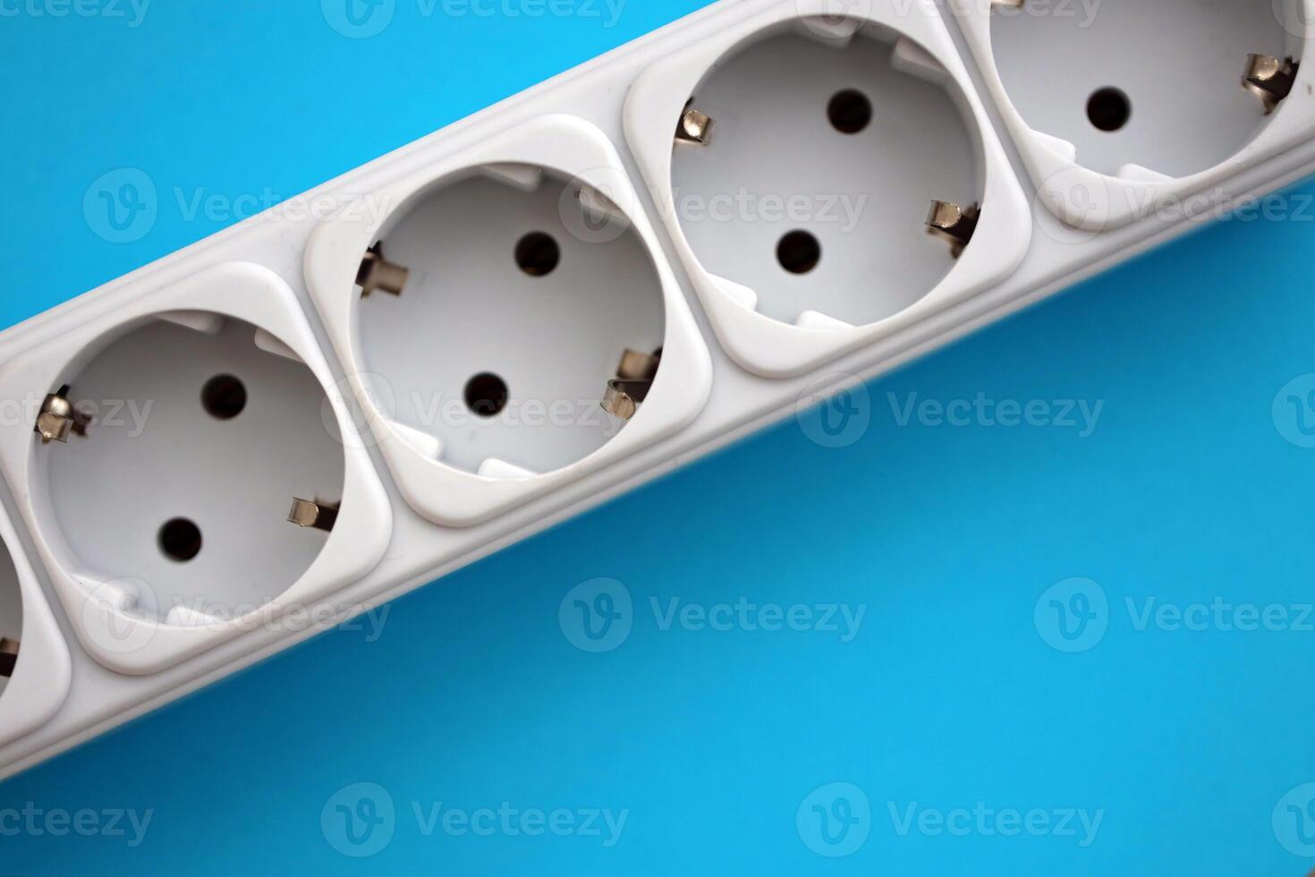 White electrical multi plug extender with european socket on bright blue background photo