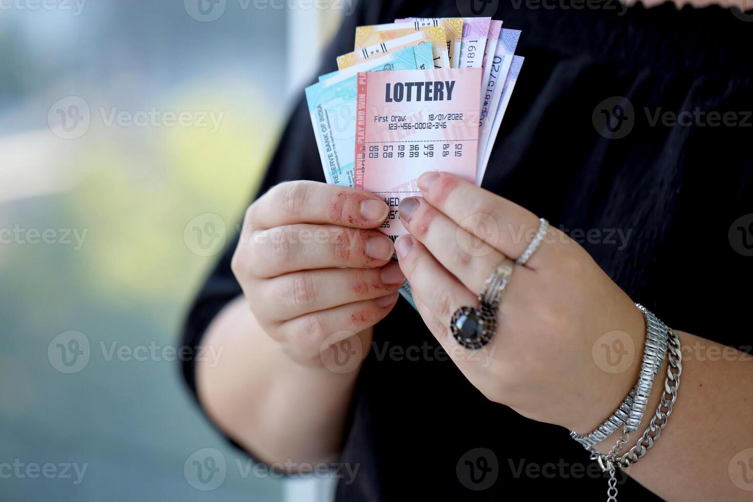 Woman hands with indian rupees bills and lottery ticket. Concept of gambling and winning money in indian lottery photo